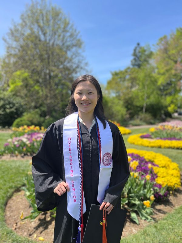 student smiling in black graduation gown