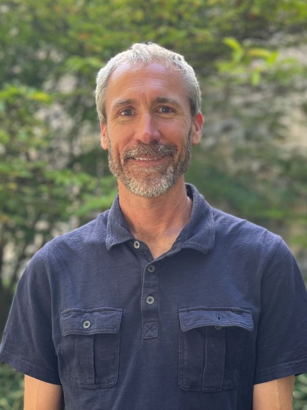 faculty member smiling with blue shirt on