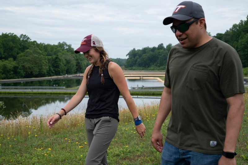 Two people walking in front of fish ponds