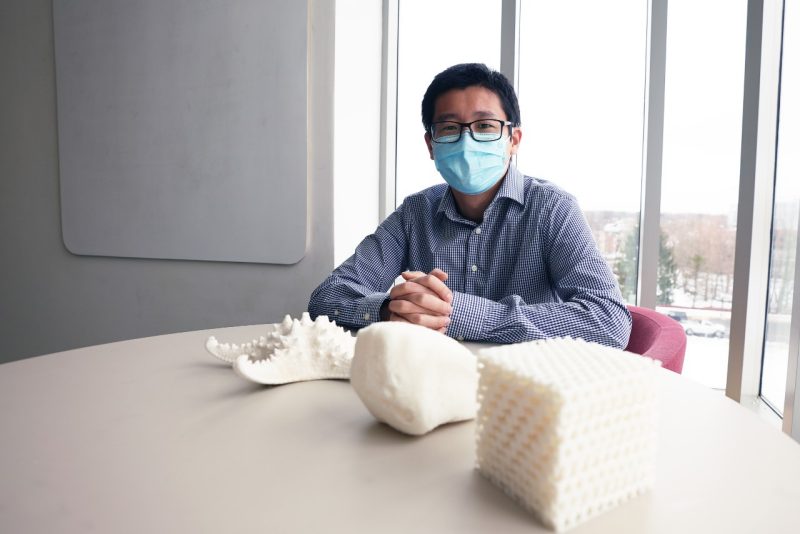 Ling Li with a starfish skeleton and 3D-printed enlargements.