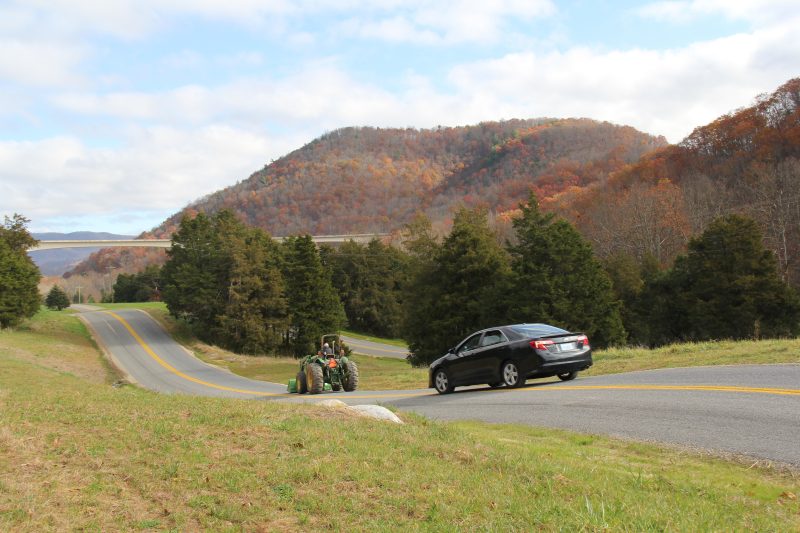 Car and tractor drive on the Rural Roadway