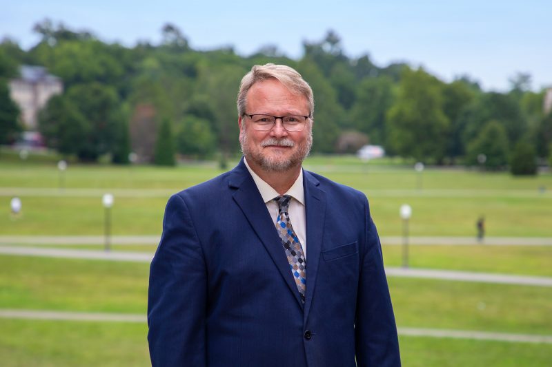 University Libraries Dean Tyler Walters stands outside of Newman Library and gazes toward the Drillfield