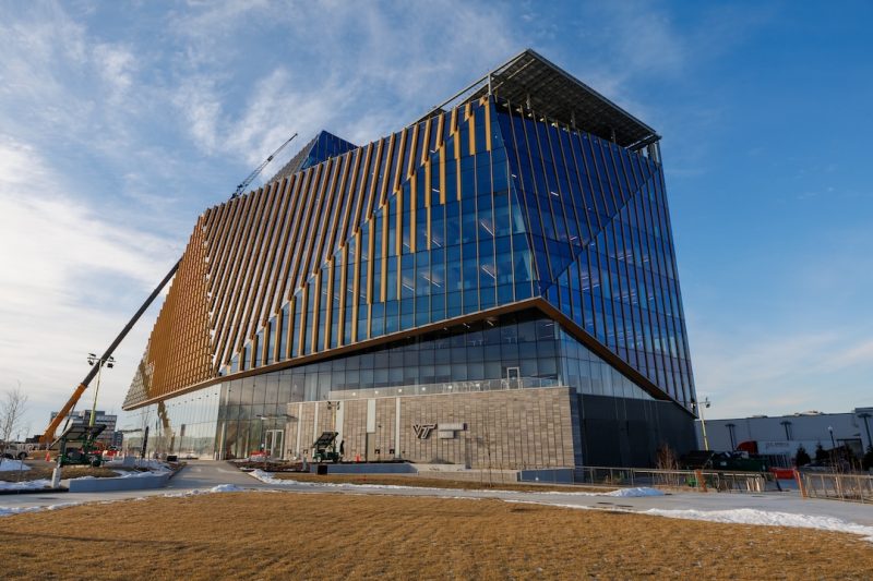 a large glass building reflecting the clear blue sky