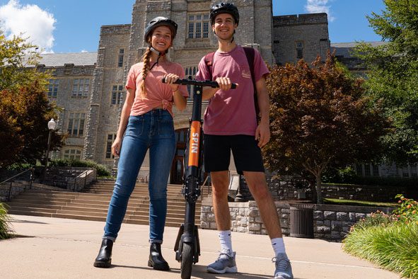 Students pose with Spin scooters